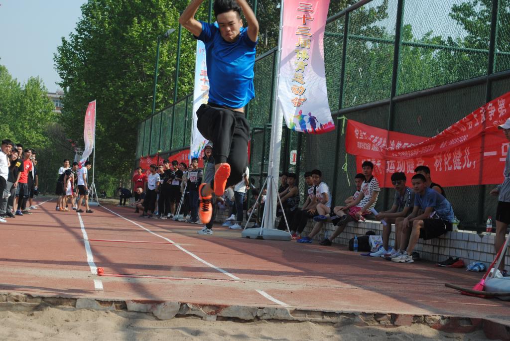 图为我院跳远运动员比赛留影